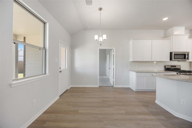 10919 Independence Rd, Cleveland, TX 77328 - kitchen with stainless steel appliances, white cabinetry, tasteful backsplash, lofted ceiling, and healthy amount of natural light