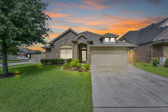 6903 Lamar Park Ln, Houston, TX 77049 - french country home with brick siding, concrete driveway, an attached garage, and a shingled roof