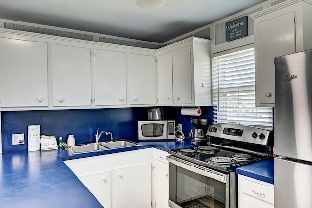 16607 Bahama Way, Jamaica Beach, TX 77554 - kitchen featuring appliances with stainless steel finishes, white cabinetry, and dark countertops