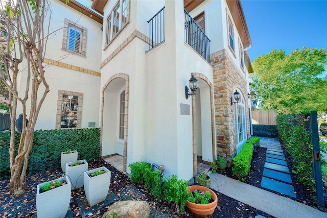 4035 Gramercy St, Houston, TX 77025 - view of property exterior featuring stone siding, stucco siding, and a balcony