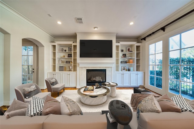 4035 Gramercy St, Houston, TX 77025 - living area with ornamental molding, arched walkways, wood finished floors, a premium fireplace, and recessed lighting