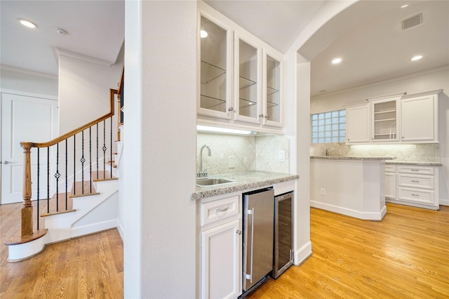 4035 Gramercy St, Houston, TX 77025 - indoor wet bar with wine cooler, light wood finished floors, ornamental molding, tasteful backsplash, and recessed lighting