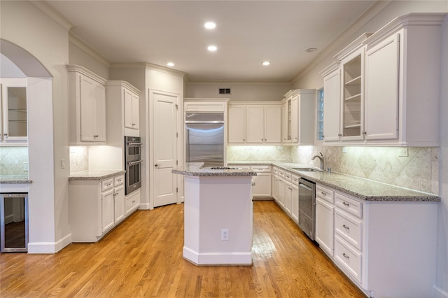 4035 Gramercy St, Houston, TX 77025 - kitchen featuring wine cooler, white cabinetry, a center island, appliances with stainless steel finishes, and ornamental molding