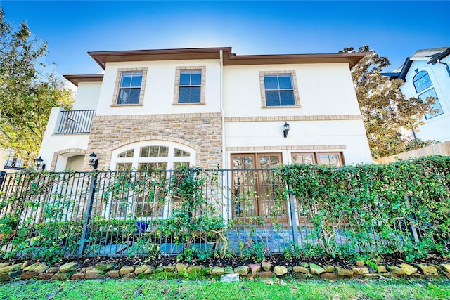 4035 Gramercy St, Houston, TX 77025 - view of front facade featuring stone siding, a balcony, and stucco siding