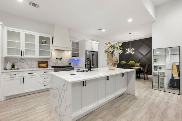 12 Rd 662, Dayton, TX 77535 - kitchen with stainless steel refrigerator with ice dispenser, premium range hood, white cabinets, an island with sink, and recessed lighting