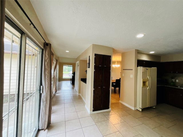 6404 Quail Meadow Dr, Houston, TX 77035 - hallway featuring a textured ceiling, recessed lighting, light tile patterned floors, and a chandelier