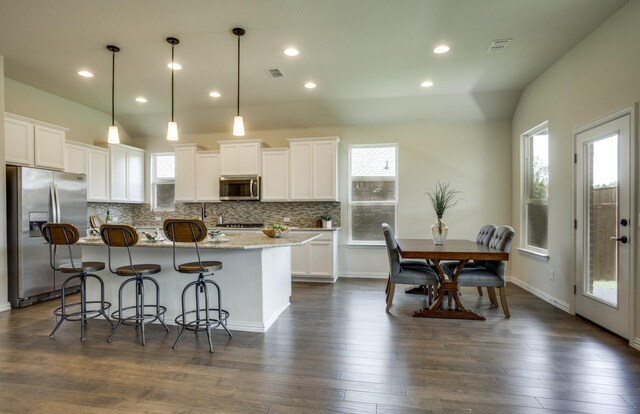 15898 Hayes Market Loop, Conroe, TX 77302 - kitchen with appliances with stainless steel finishes, decorative backsplash, healthy amount of natural light, white cabinets, and recessed lighting