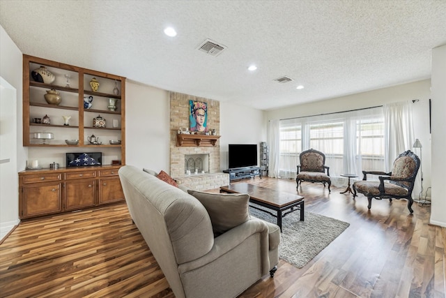 12907 Avenida Vaquero St, Houston, TX 77077 - living room with a textured ceiling, wood finished floors, recessed lighting, and a large fireplace