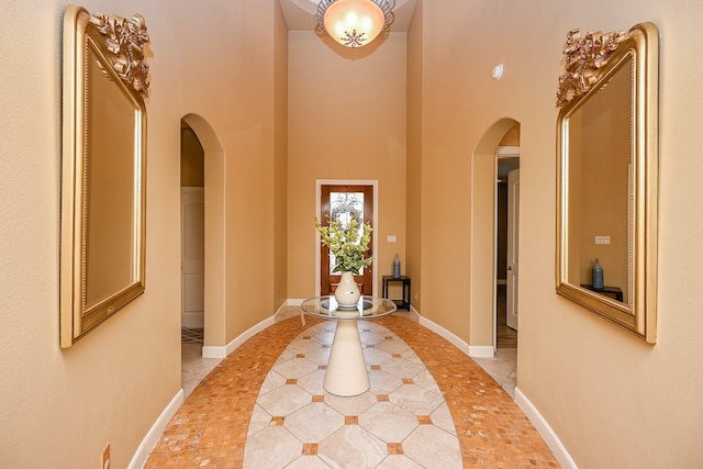 27814 Cenizo Park Ct, Katy, TX 77494 - corridor featuring arched walkways, inlaid floor details, a high ceiling, and light tile patterned floors