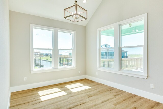 591 Pompano Dr, Freeport, TX 77541 - unfurnished room with a chandelier, wood finished floors, and lofted ceiling