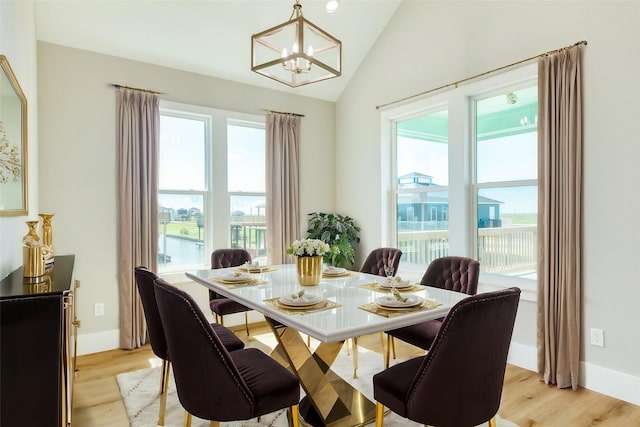 591 Pompano Dr, Freeport, TX 77541 - dining space with a chandelier, vaulted ceiling, and light wood-style flooring