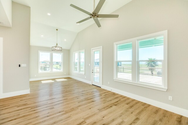 591 Pompano Dr, Freeport, TX 77541 - unfurnished room with light wood-style flooring, high vaulted ceiling, ceiling fan, a chandelier, and recessed lighting