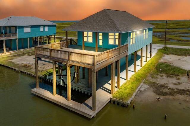591 Pompano Dr, Freeport, TX 77541 - rear view of house featuring roof with shingles and a deck with water view