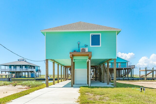 591 Pompano Dr, Freeport, TX 77541 - raised beach house featuring a carport, driveway, a shingled roof, and stairway