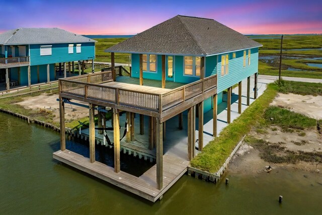 591 Pompano Dr, Freeport, TX 77541 - back of house with a shingled roof and a deck with water view