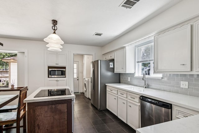 7927 Litchfield Ln, Spring, TX 77379 - kitchen with stainless steel appliances, washing machine and clothes dryer, decorative backsplash, and healthy amount of natural light