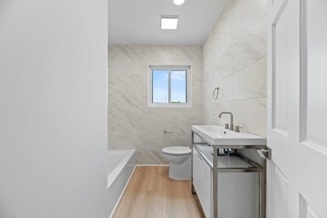 4406 Merwin St, Houston, TX 77027 - bathroom featuring vanity, wood finished floors, and tile walls