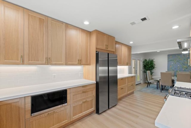 4406 Merwin St, Houston, TX 77027 - kitchen with freestanding refrigerator, black microwave, light brown cabinetry, light wood-style flooring, and light countertops