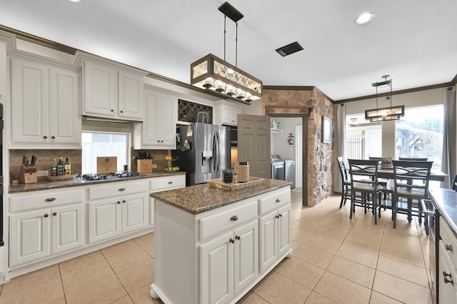1415 Kennoway Park Dr, Spring, TX 77379 - kitchen with appliances with stainless steel finishes, washer and dryer, healthy amount of natural light, light tile patterned floors, and ornamental molding