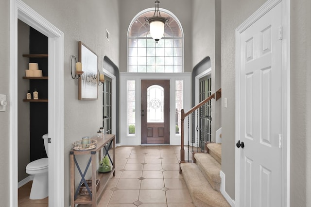1415 Kennoway Park Dr, Spring, TX 77379 - entryway with a textured wall, stairway, tile patterned flooring, and a high ceiling