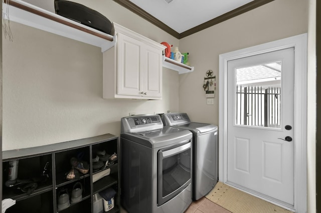 1415 Kennoway Park Dr, Spring, TX 77379 - washroom featuring washing machine and clothes dryer, cabinet space, crown molding, and light tile patterned flooring