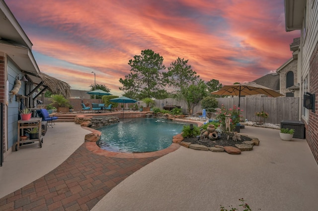 1415 Kennoway Park Dr, Spring, TX 77379 - pool at dusk featuring a patio, a pool with connected hot tub, and a fenced backyard