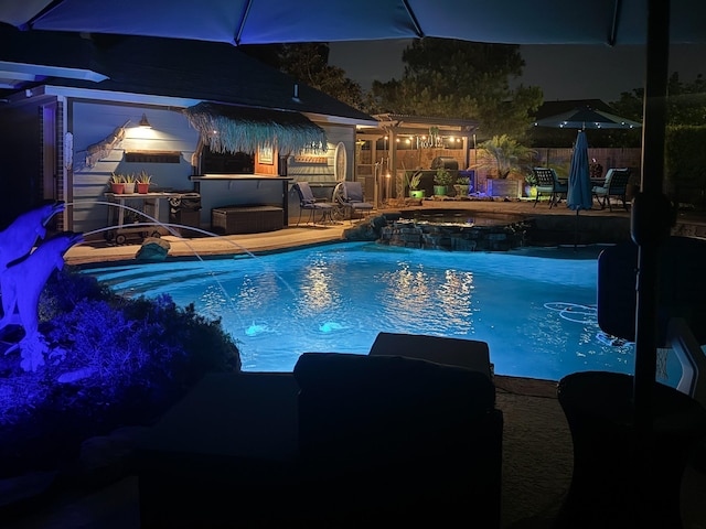 1415 Kennoway Park Dr, Spring, TX 77379 - pool at night featuring an outdoor hot tub and a patio
