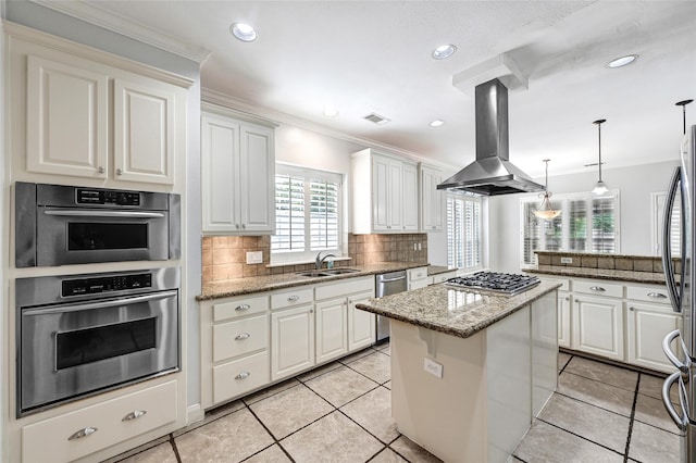 13322 Castlecombe Dr, Houston, TX 77044 - kitchen with island range hood, appliances with stainless steel finishes, a center island, backsplash, and light stone counters