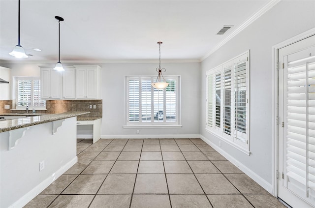 13322 Castlecombe Dr, Houston, TX 77044 - kitchen with light tile patterned floors, ornamental molding, tasteful backsplash, a kitchen bar, and white cabinetry