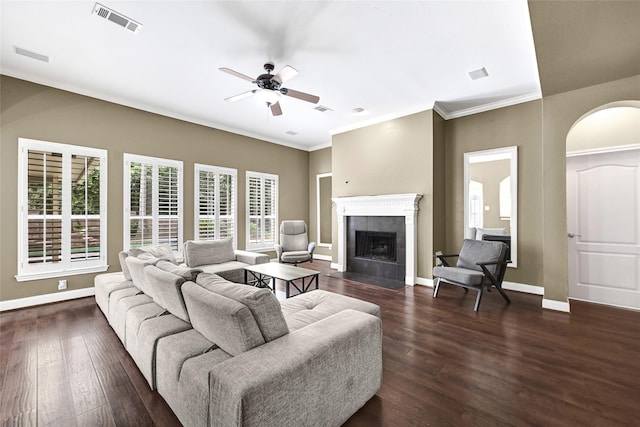 13322 Castlecombe Dr, Houston, TX 77044 - living room featuring ceiling fan, dark wood-style floors, crown molding, arched walkways, and a tiled fireplace