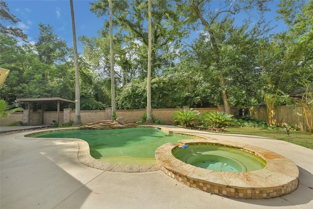 13322 Castlecombe Dr, Houston, TX 77044 - view of pool with a fenced backyard, view of wooded area, a pool with connected hot tub, and a putting green