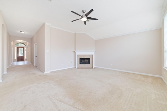 12714 Madera Canyon Ln, Tomball, TX 77377 - unfurnished living room featuring arched walkways, ceiling fan, light carpet, a tile fireplace, and crown molding