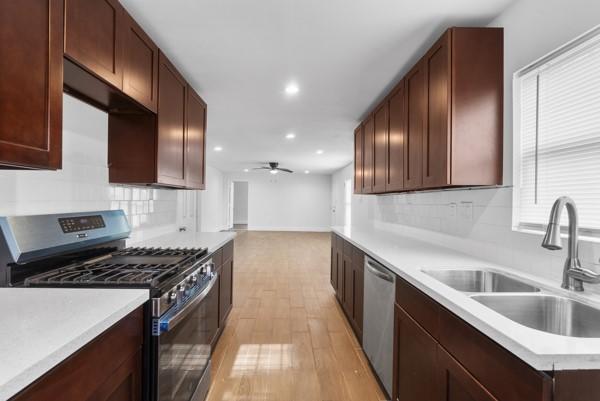 2202 Garvey Dr, Pasadena, TX 77506 - kitchen featuring stainless steel appliances, light wood-style floors, recessed lighting, tasteful backsplash, and light countertops