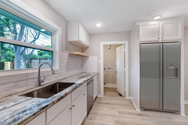 5858 Beldart St, Houston, TX 77033 - kitchen featuring appliances with stainless steel finishes, light stone counters, white cabinetry, light wood-style floors, and recessed lighting