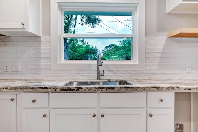 5858 Beldart St, Houston, TX 77033 - kitchen with white cabinets, tasteful backsplash, and light stone countertops