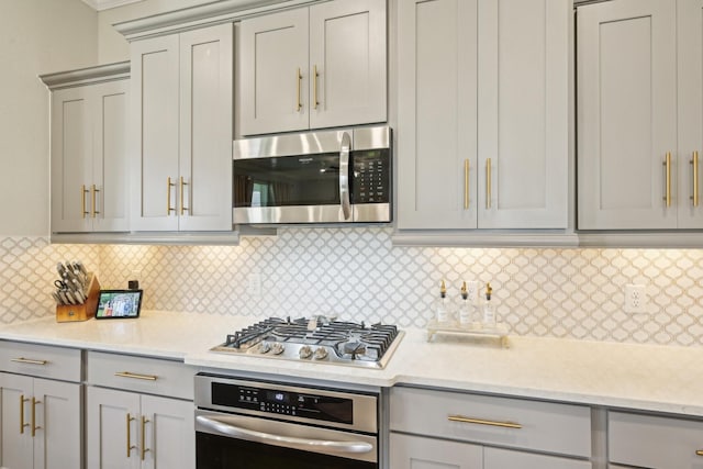 2018 Oxley Manor Ln, Richmond, TX 77469 - kitchen with stainless steel appliances, gray cabinetry, and tasteful backsplash