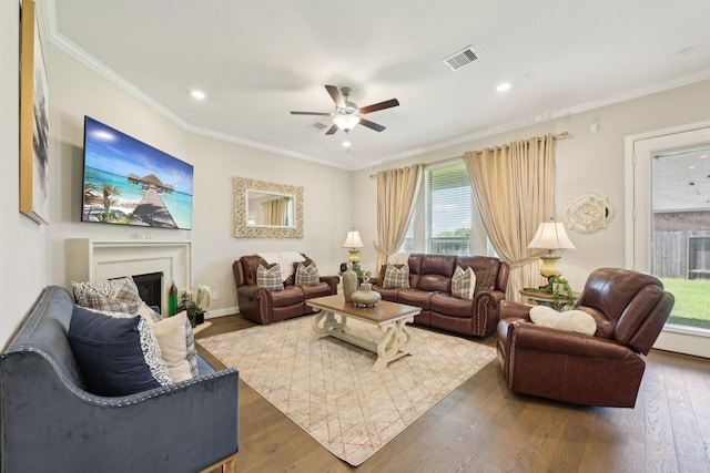 2018 Oxley Manor Ln, Richmond, TX 77469 - living area with ceiling fan, a glass covered fireplace, wood finished floors, ornamental molding, and recessed lighting