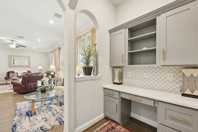 2018 Oxley Manor Ln, Richmond, TX 77469 - home office featuring built in desk, dark wood-style flooring, ornamental molding, ceiling fan, and recessed lighting
