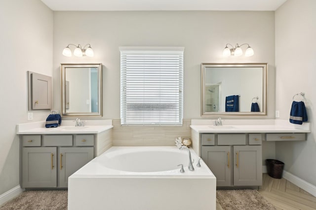 2018 Oxley Manor Ln, Richmond, TX 77469 - full bathroom featuring a garden tub and two vanities