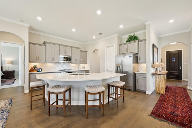 2018 Oxley Manor Ln, Richmond, TX 77469 - kitchen with gray cabinets, appliances with stainless steel finishes, arched walkways, crown molding, and recessed lighting
