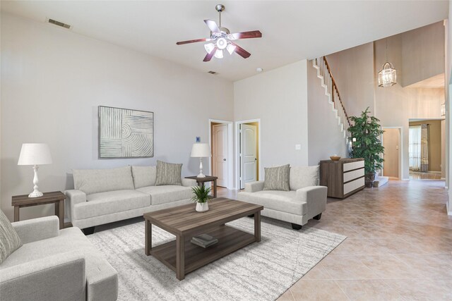 6103 Timbermoss Ct, League City, TX 77573 - living area featuring ceiling fan, light tile patterned floors, a towering ceiling, and stairs