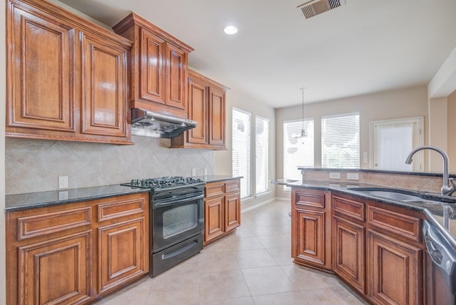 6103 Timbermoss Ct, League City, TX 77573 - kitchen with black range with gas cooktop, under cabinet range hood, brown cabinetry, stainless steel dishwasher, and decorative backsplash
