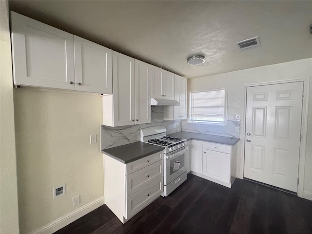 10124 Homestead Rd, Houston, TX 77016 - kitchen featuring white range with gas cooktop, under cabinet range hood, dark wood finished floors, white cabinets, and decorative backsplash