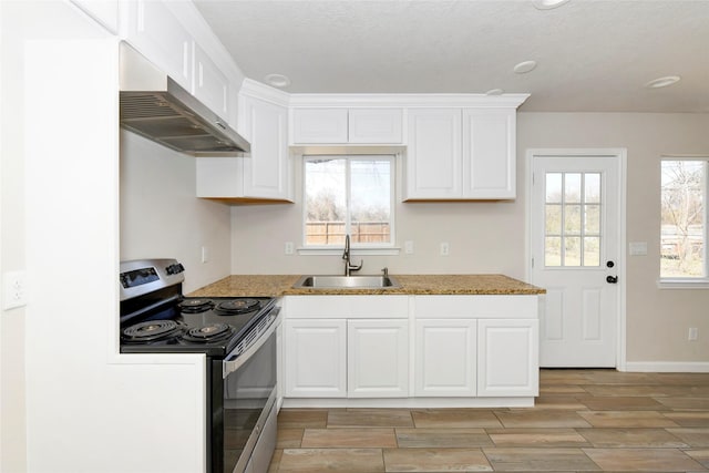 1531 Lahn Rd, New Braunfels, TX 78130 - kitchen with stainless steel electric range, wall chimney exhaust hood, white cabinetry, and wood tiled floors