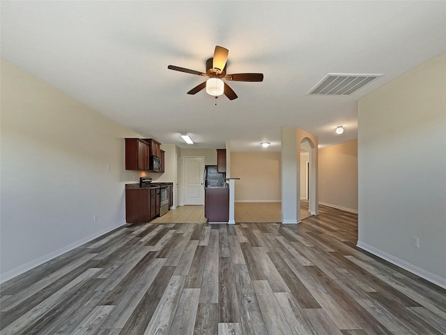 8839 Hazel Rose Sky Dr, Humble, TX 77338 - unfurnished living room with a ceiling fan, wood finished floors, and arched walkways