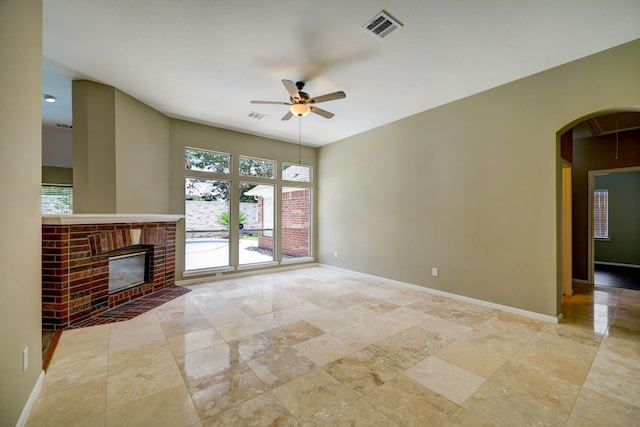 9847 Bestin Ln, Houston, TX 77065 - unfurnished living room featuring a ceiling fan, arched walkways, and a brick fireplace
