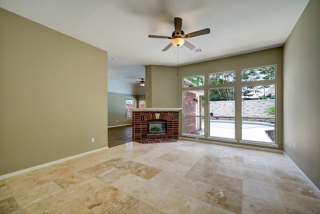 9847 Bestin Ln, Houston, TX 77065 - unfurnished living room featuring a ceiling fan, a brick fireplace, and light stone finish floors
