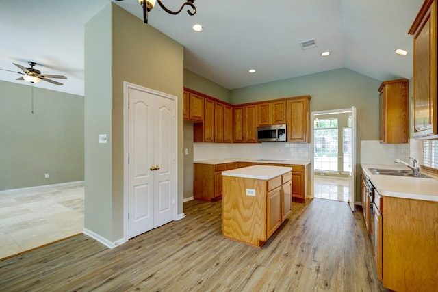 9847 Bestin Ln, Houston, TX 77065 - kitchen with stainless steel microwave, a center island, tasteful backsplash, a ceiling fan, and light countertops