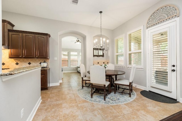 13839 Oak Fair Bnd, Cypress, TX 77429 - dining area featuring light tile patterned floors, a chandelier, arched walkways, and a ceiling fan