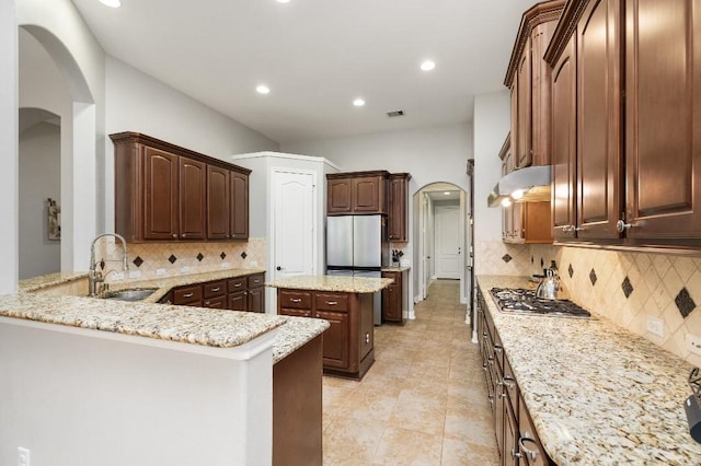 13839 Oak Fair Bnd, Cypress, TX 77429 - kitchen with arched walkways, appliances with stainless steel finishes, tasteful backsplash, light stone countertops, and recessed lighting